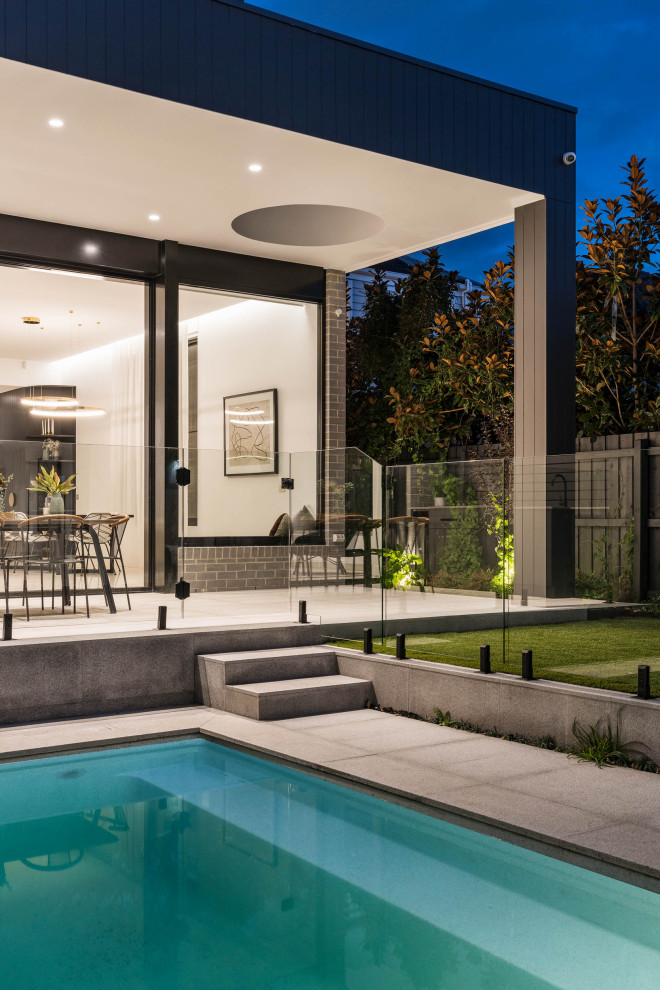 Idées déco pour un grand Abris de piscine et pool houses arrière contemporain rectangle avec des pavés en pierre naturelle.