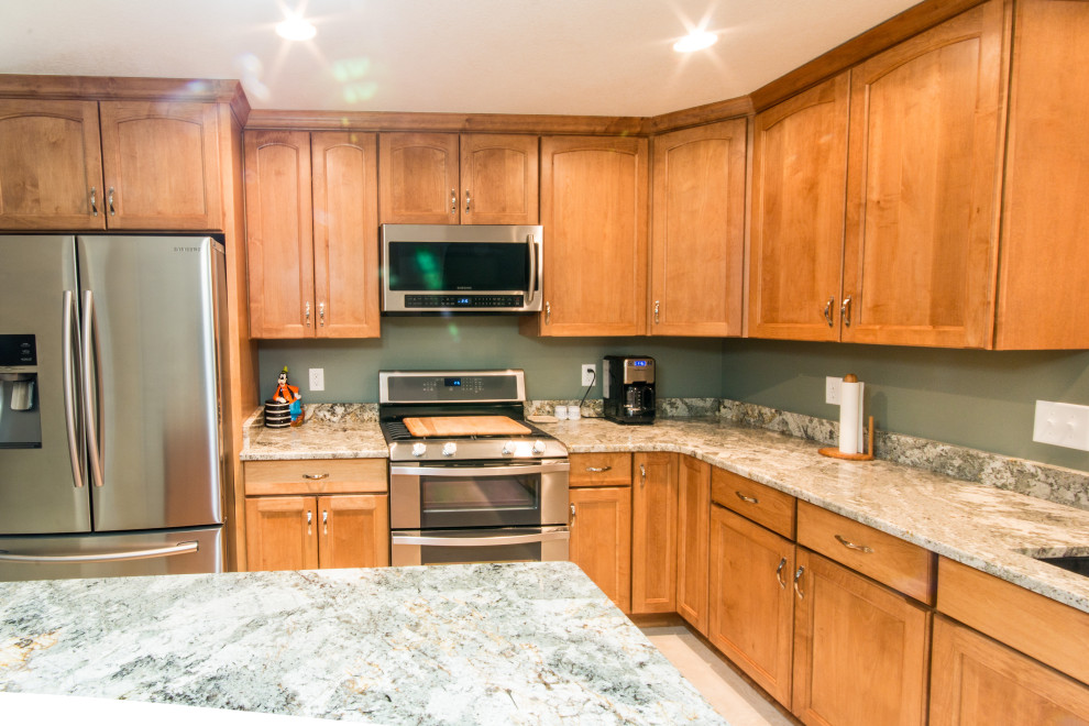 Inspiration for a mid-sized l-shaped cement tile floor eat-in kitchen remodel with an undermount sink, flat-panel cabinets, medium tone wood cabinets, granite countertops, stainless steel appliances and an island