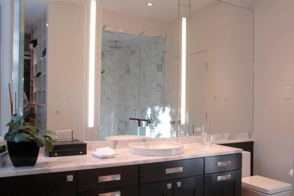 Design ideas for a contemporary master bathroom in Houston with a vessel sink, shaker cabinets, dark wood cabinets, marble benchtops, a freestanding tub, an alcove shower, a one-piece toilet, white tile, white walls and limestone floors.