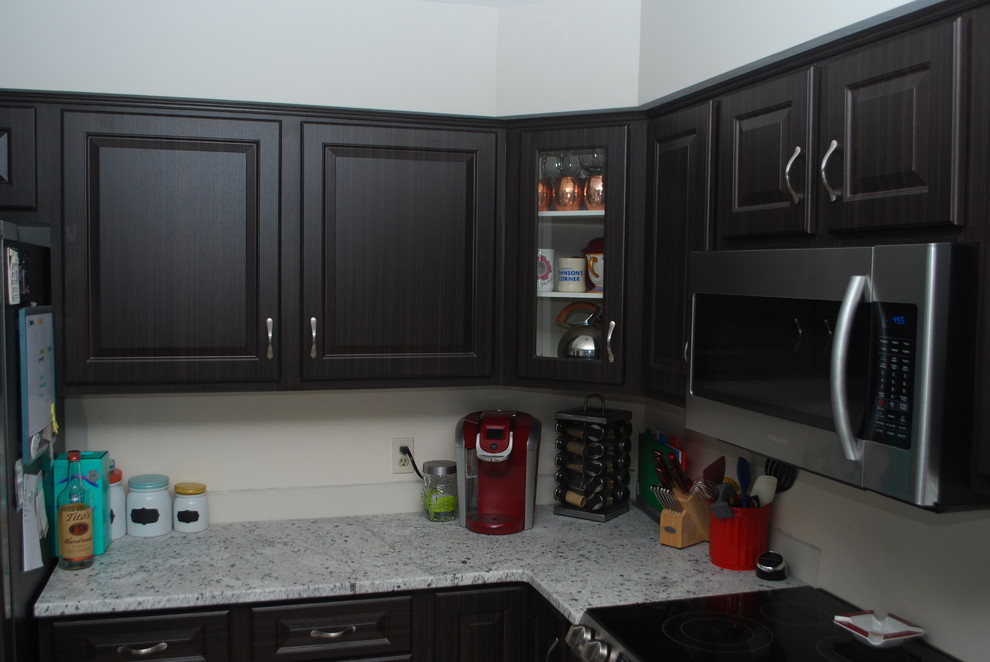 Photo of a mid-sized traditional l-shaped separate kitchen in Other with raised-panel cabinets, stainless steel appliances, with island, a double-bowl sink, dark wood cabinets, quartzite benchtops, terra-cotta floors, beige floor and white benchtop.