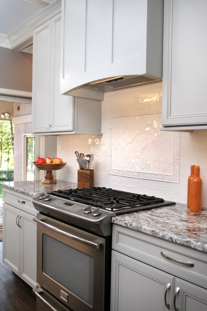 Eat-in kitchen - large transitional l-shaped porcelain tile eat-in kitchen idea with a farmhouse sink, recessed-panel cabinets, gray cabinets, granite countertops, white backsplash, ceramic backsplash, stainless steel appliances and two islands