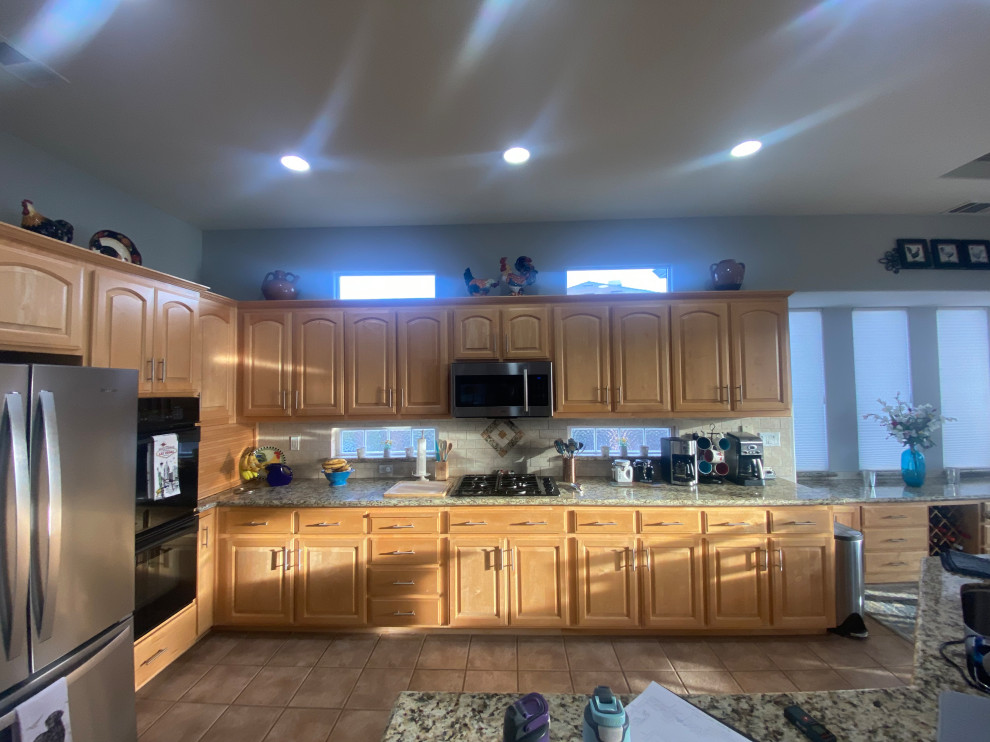 Mid-sized transitional l-shaped eat-in kitchen in Sacramento with raised-panel cabinets, quartz benchtops, grey splashback, glass tile splashback, stainless steel appliances and with island.