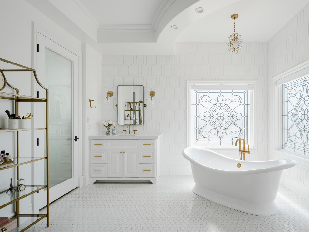 Пример оригинального дизайна: большая главная ванная комната с фасадами с выступающей филенкой, белыми фасадами, отдельно стоящей ванной, открытым душем, унитазом-моноблоком, белой плиткой, керамической плиткой, белыми стенами, полом из керамогранита, врезной раковиной, столешницей из искусственного кварца, белым полом, открытым душем, белой столешницей, сиденьем для душа, тумбой под две раковины, встроенной тумбой, любым потолком и любой отделкой стен