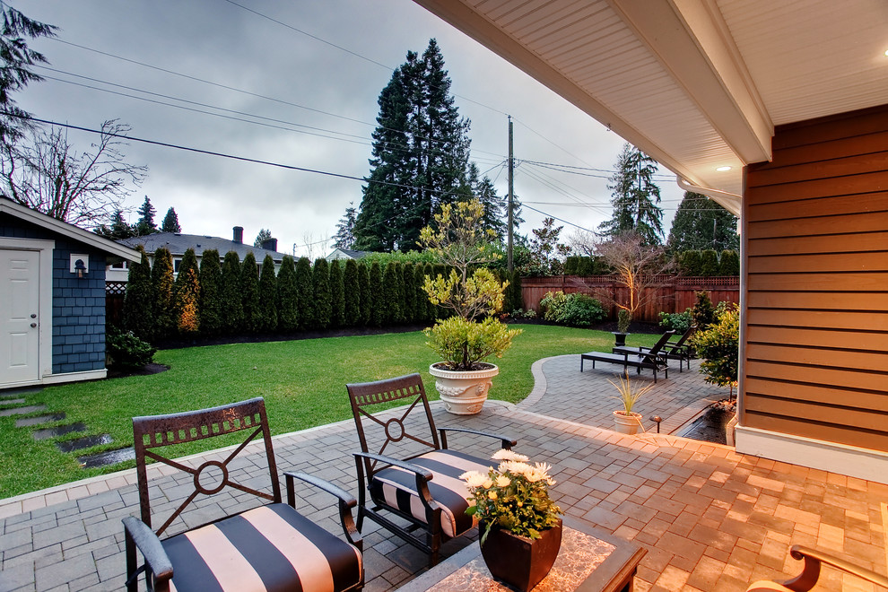 Inspiration for a contemporary patio in Vancouver with concrete pavers and a roof extension.