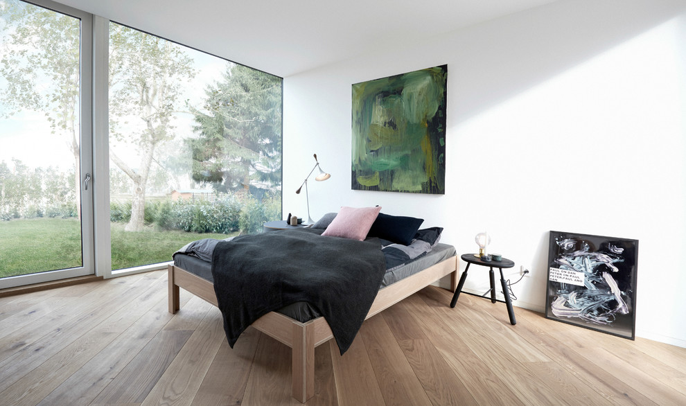 This is an example of a large scandinavian master bedroom in Copenhagen with white walls, light hardwood floors and no fireplace.
