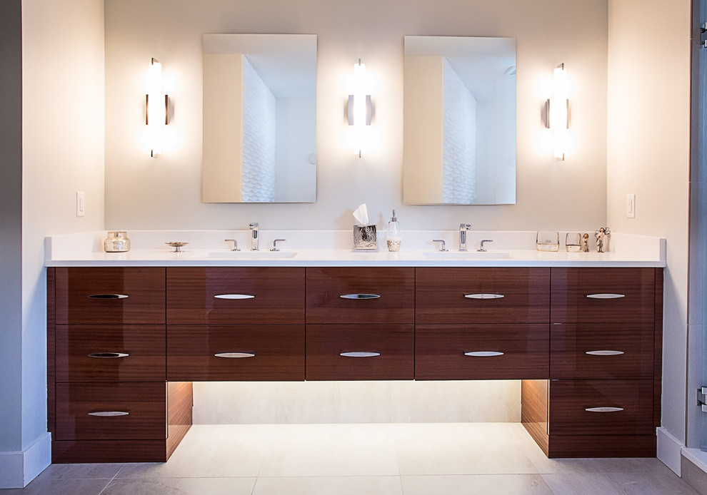 Photo of a mid-sized contemporary master bathroom in Denver with flat-panel cabinets, engineered quartz benchtops, brown cabinets, beige walls, ceramic floors and an undermount sink.