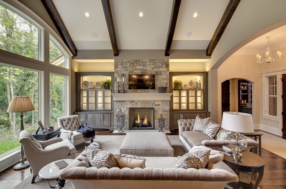 Inspiration for a transitional living room in Minneapolis with beige walls, dark hardwood floors, a standard fireplace, a stone fireplace surround and brown floor.