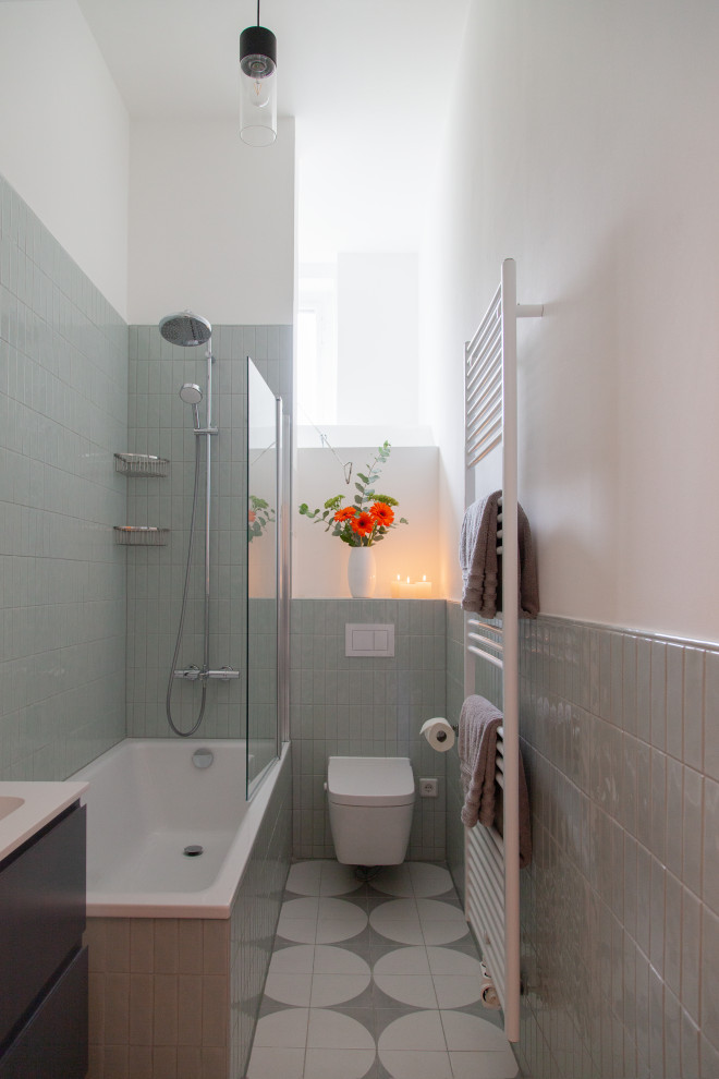 Idées déco pour une salle d'eau longue et étroite et grise et blanche contemporaine de taille moyenne avec un placard avec porte à panneau surélevé, des portes de placard grises, une baignoire posée, un combiné douche/baignoire, WC séparés, un carrelage vert, des carreaux de céramique, un mur blanc, un sol en carrelage de céramique, un lavabo intégré, un plan de toilette en stratifié, un sol gris, aucune cabine, un plan de toilette blanc, meuble simple vasque, meuble-lavabo suspendu et un plafond décaissé.
