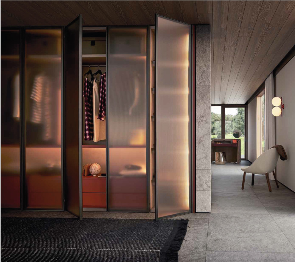 Imagen de armario vestidor de mujer minimalista grande con armarios tipo vitrina, puertas de armario de madera clara, suelo de baldosas de porcelana y suelo gris