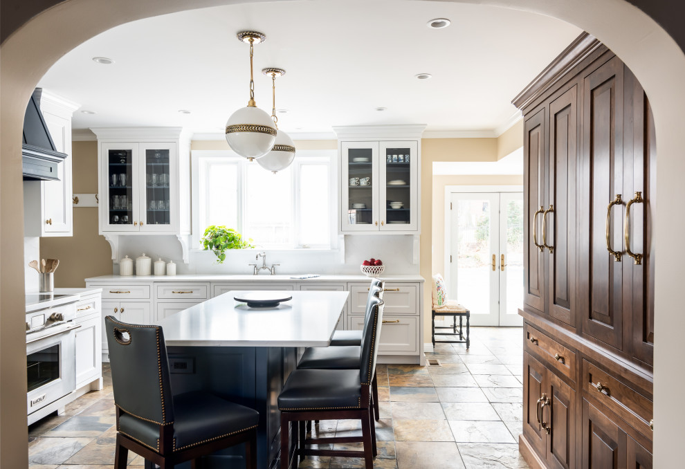 Inspiration for a mid-sized traditional l-shaped eat-in kitchen in St Louis with a single-bowl sink, quartz benchtops, white splashback, stone slab splashback, panelled appliances, slate floors, with island, multi-coloured floor and white benchtop.