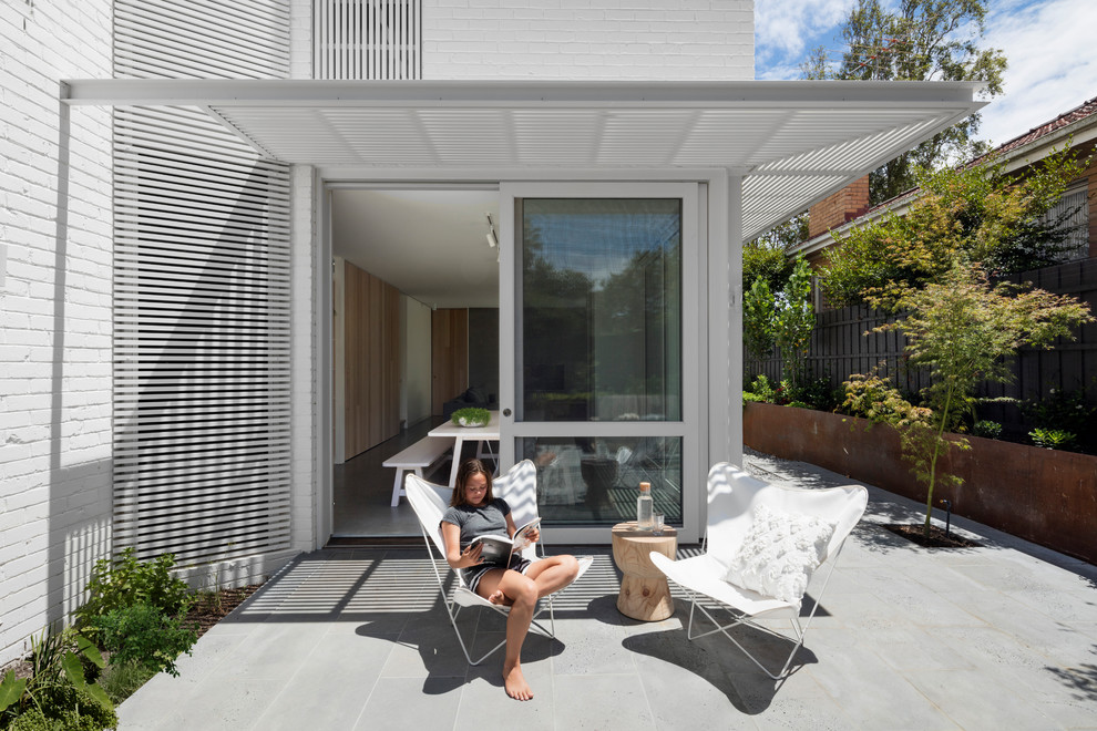 Large contemporary three-storey brick white exterior in Melbourne with a gable roof.