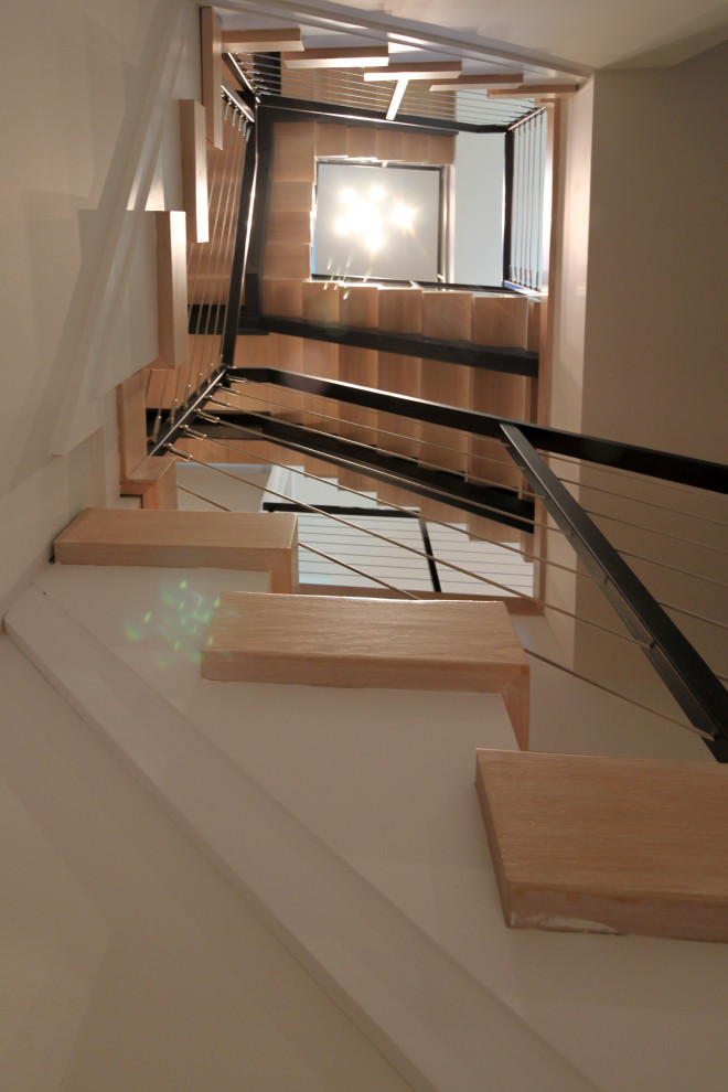 Idées déco pour un grand escalier flottant éclectique avec des marches en bois, un garde-corps en métal et un mur en parement de brique.