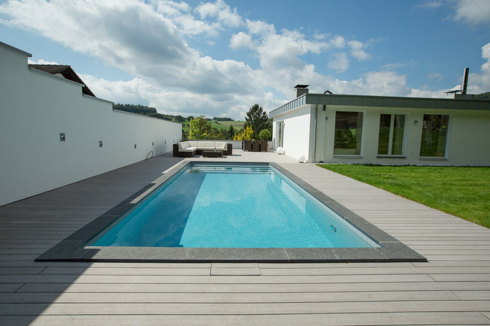 Design ideas for a large contemporary side yard rectangular pool in Frankfurt with decking.