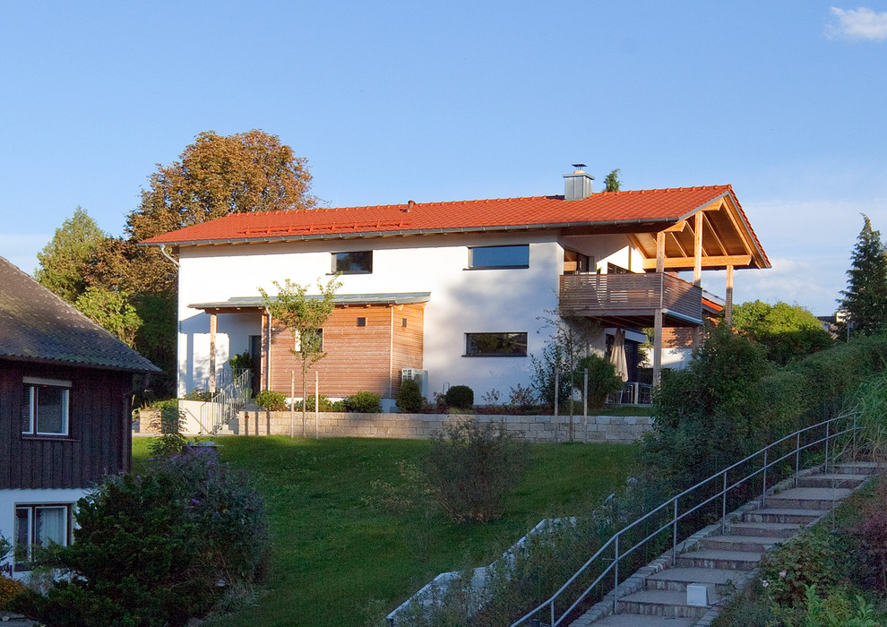 Ejemplo de fachada de casa blanca y roja actual grande de dos plantas con revestimientos combinados, tejado a dos aguas y tejado de teja de barro