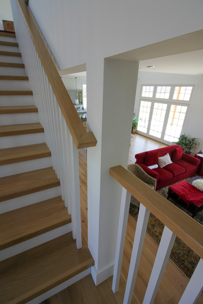 Diseño de escalera en U de estilo de casa de campo de tamaño medio con escalones de madera, contrahuellas de madera, barandilla de madera y machihembrado