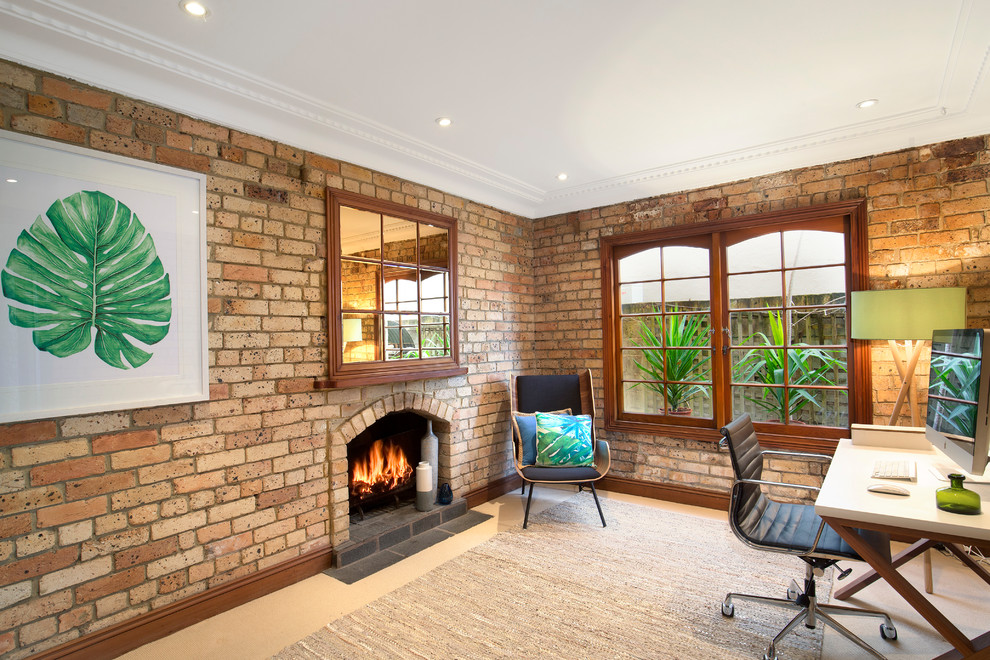 Eclectic study room in Sydney with carpet, a standard fireplace, a brick fireplace surround, a freestanding desk, beige floor and brown walls.