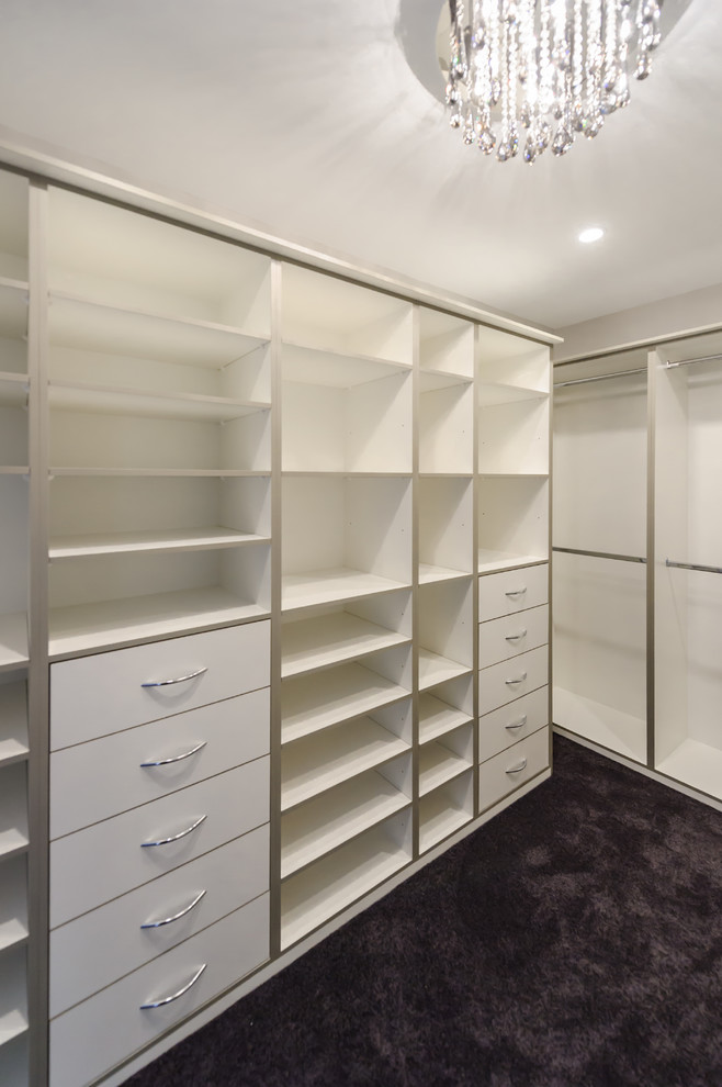 Inspiration for an expansive modern women's walk-in wardrobe in Melbourne with open cabinets, white cabinets and carpet.
