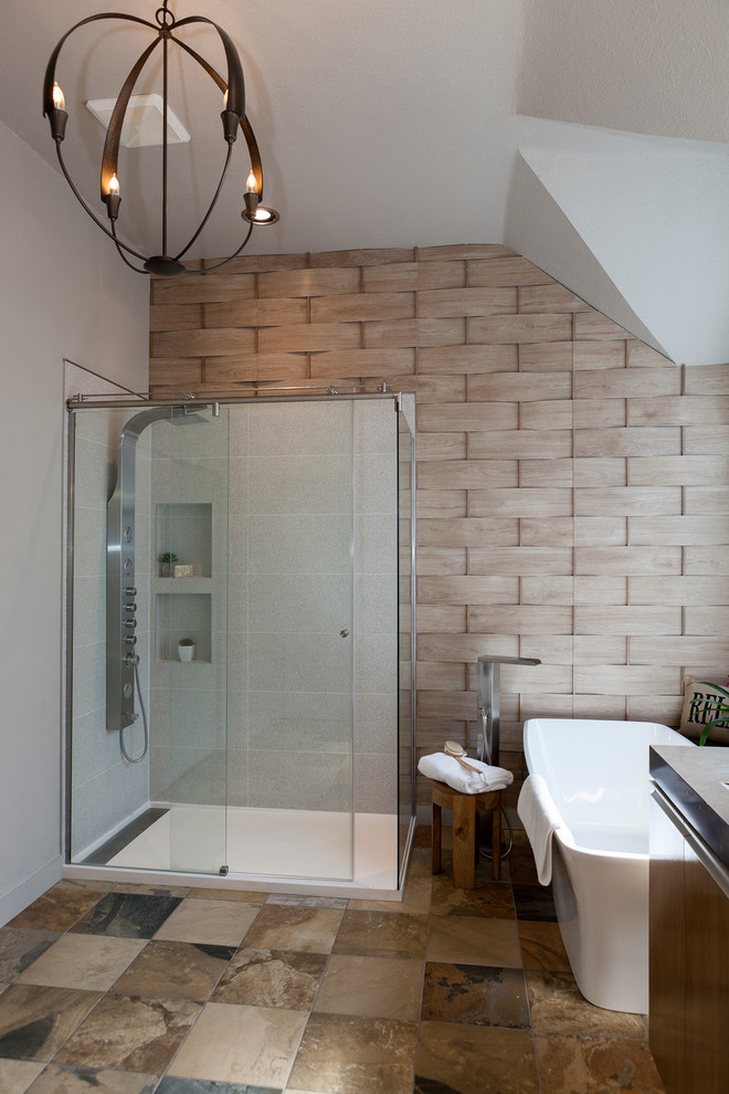 Photo of a mid-sized contemporary master bathroom in Dallas with flat-panel cabinets, medium wood cabinets, a freestanding tub, an alcove shower, beige tile, slate, beige walls, slate floors, a trough sink and solid surface benchtops.