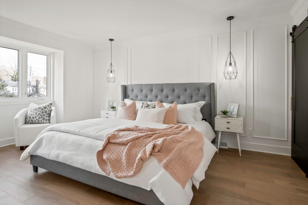 This is an example of a medium sized rural master and grey and pink bedroom in Montreal with white walls, light hardwood flooring, brown floors and wainscoting.