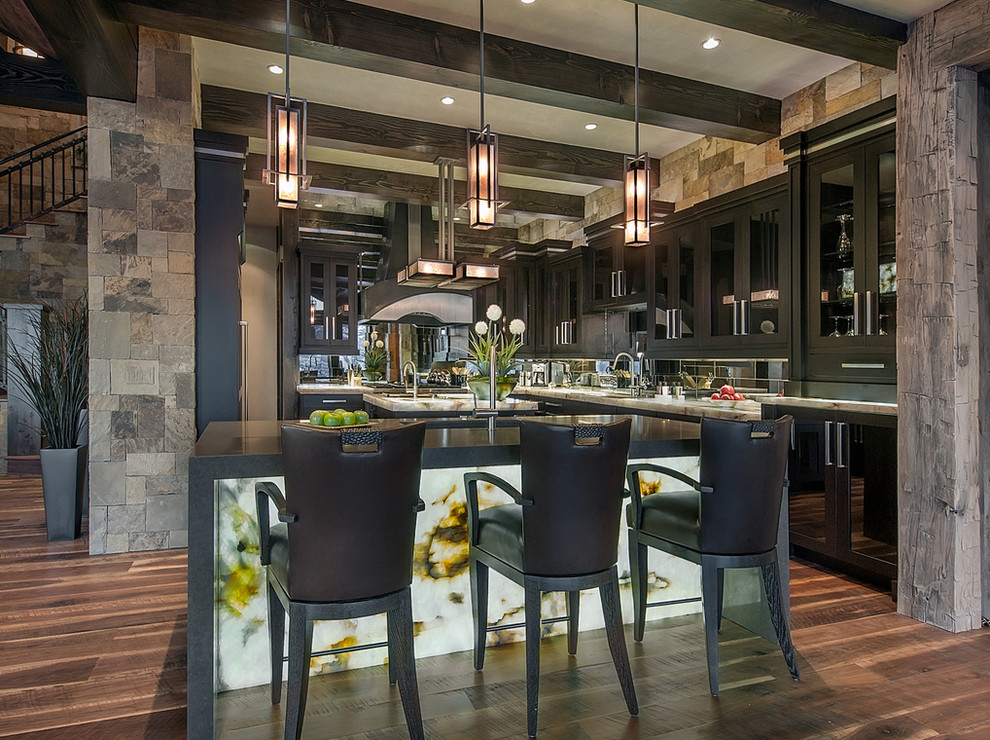 Example of a large mountain style u-shaped dark wood floor and brown floor kitchen design with a drop-in sink, shaker cabinets, dark wood cabinets, quartzite countertops, metallic backsplash, mirror backsplash, paneled appliances and two islands
