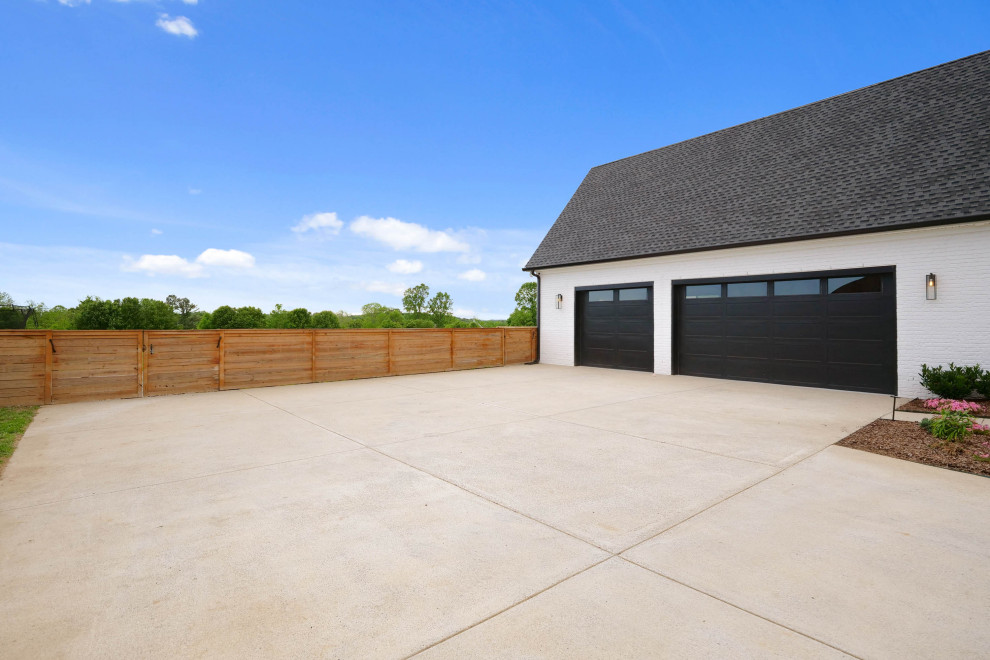 Photo of a large farmhouse attached garage in Nashville with three or more cars.