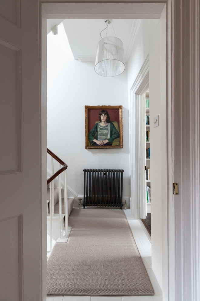 Inspiration for a small hallway in London with white walls, medium hardwood floors and white floor.