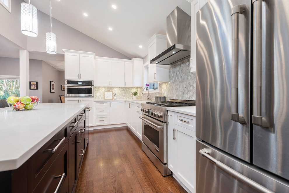 Inspiration for a large transitional l-shaped medium tone wood floor and brown floor eat-in kitchen remodel in Vancouver with an undermount sink, shaker cabinets, white cabinets, quartzite countertops, multicolored backsplash, marble backsplash, stainless steel appliances, an island and white countertops