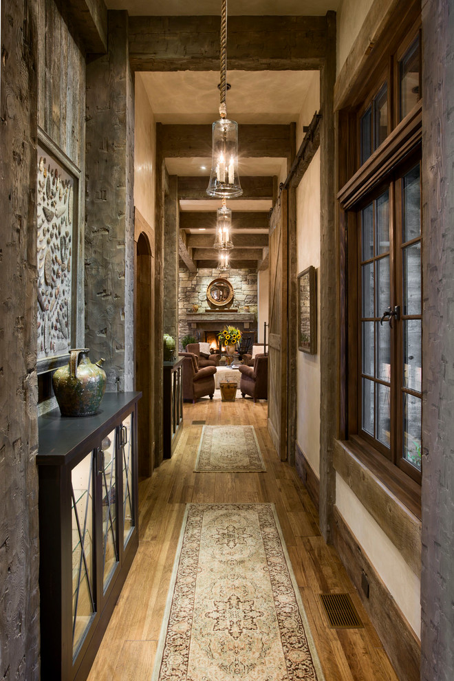 Photo of a country hallway in Other with beige walls and dark hardwood floors.