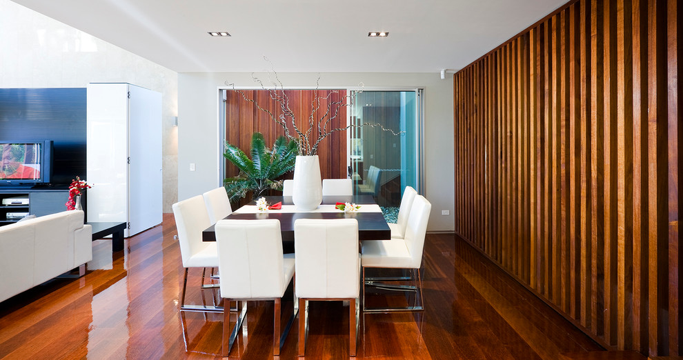 Photo of a contemporary open plan dining in Brisbane with white walls, medium hardwood floors and no fireplace.
