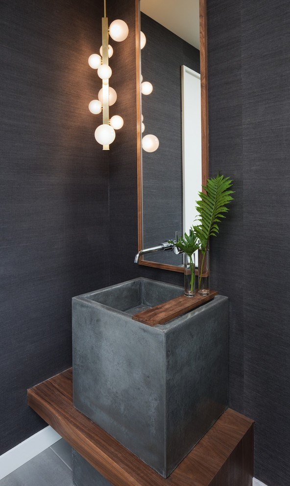 Photo of a small contemporary powder room in Minneapolis with grey walls, porcelain floors, a vessel sink, grey floor and wood benchtops.
