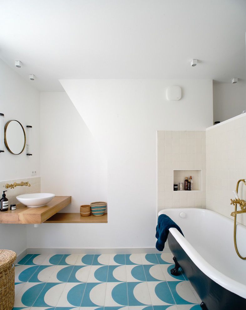 Photo of a mid-sized contemporary master bathroom in Paris with a claw-foot tub, white walls, cement tiles, a vessel sink, wood benchtops, blue floor and beige tile.