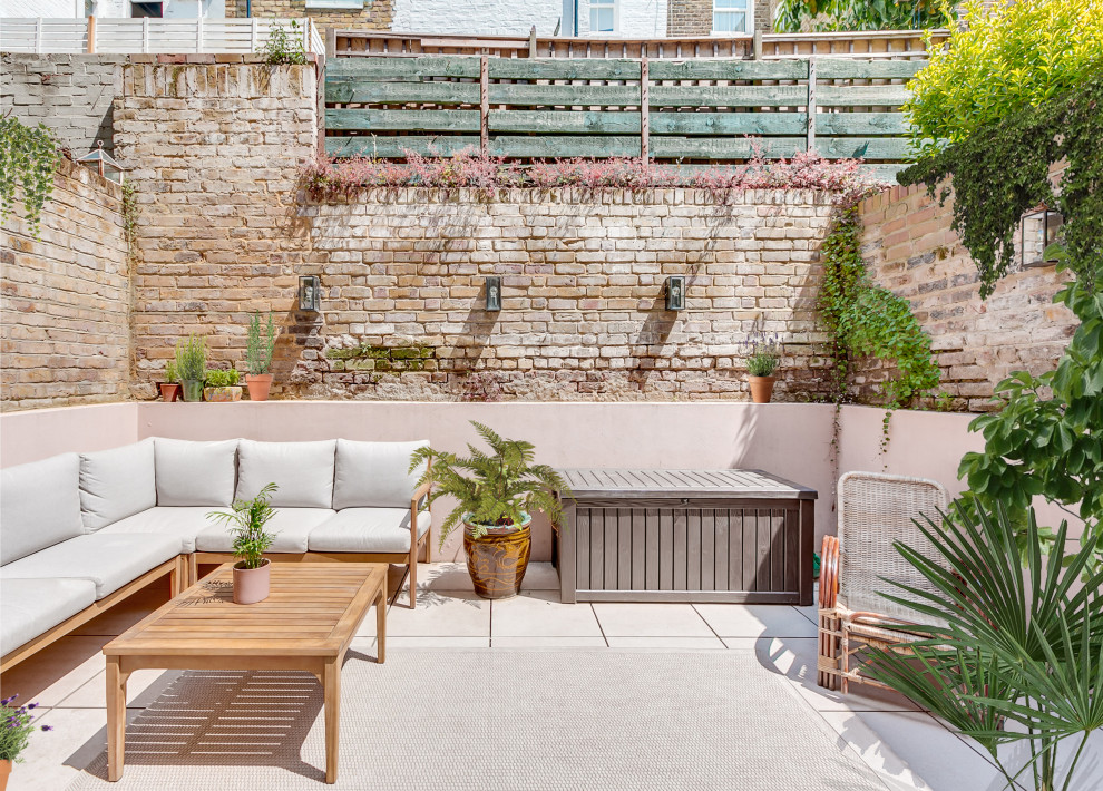 Medium sized mediterranean back ground level terrace in London with a potted garden and no cover.