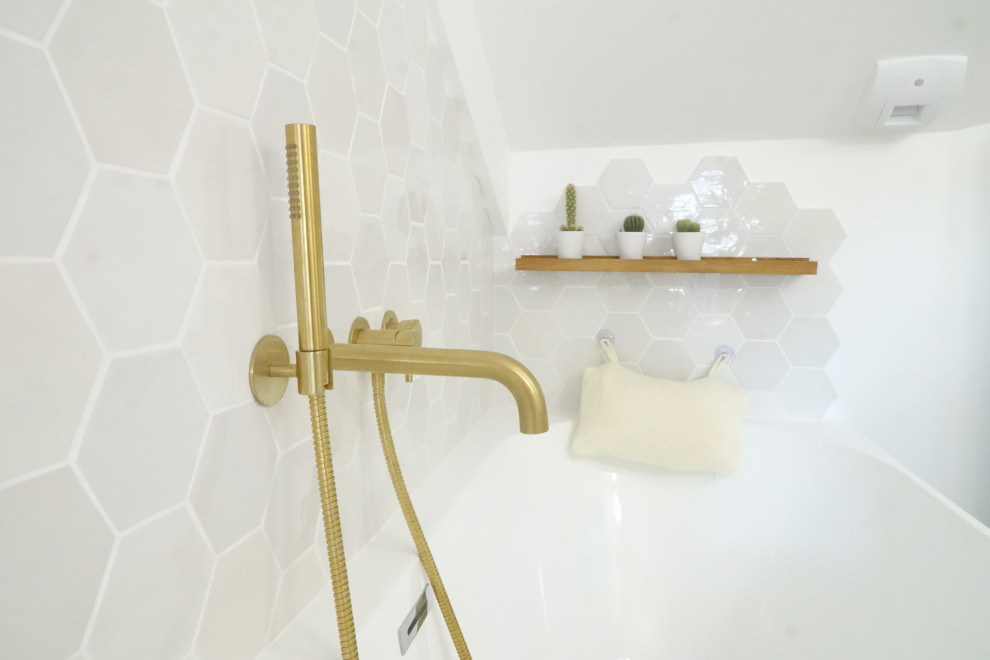 Exempel på ett litet modernt vit vitt badrum med dusch, med luckor med profilerade fronter, skåp i ljust trä, ett platsbyggt badkar, en vägghängd toalettstol, vit kakel, porslinskakel, vita väggar, vinylgolv, ett nedsänkt handfat, laminatbänkskiva och beiget golv