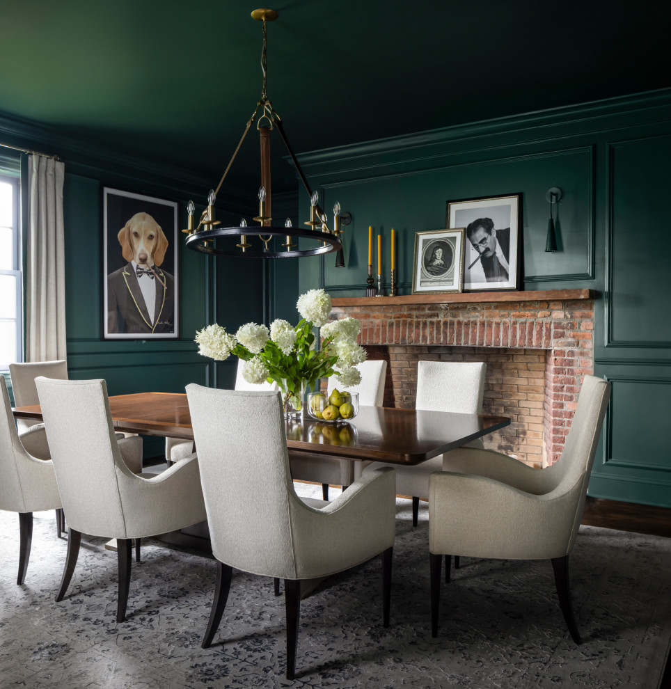 This is an example of a traditional separate dining room in New York with green walls, dark hardwood floors, brown floor and panelled walls.