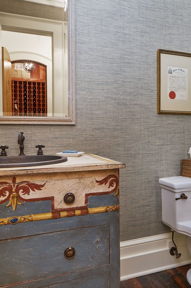 Mid-sized traditional powder room in Atlanta with furniture-like cabinets, a one-piece toilet, blue walls, medium hardwood floors, a drop-in sink, wood benchtops and distressed cabinets.