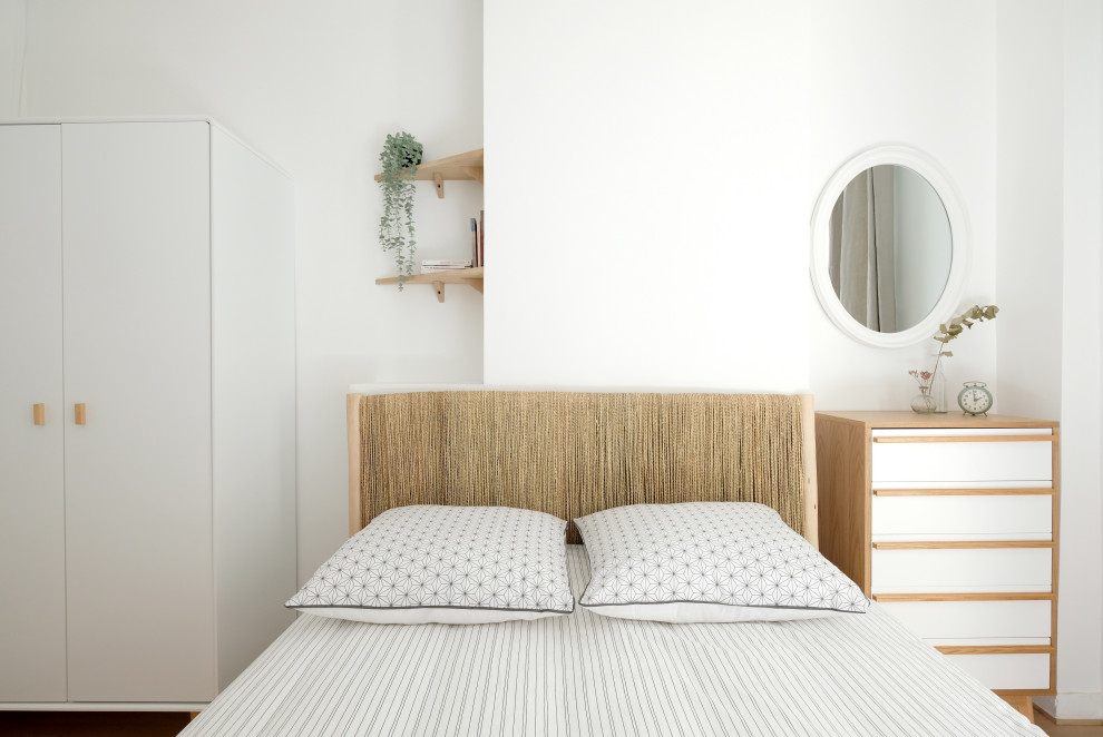 Diseño de dormitorio nórdico pequeño con paredes blancas y suelo de madera clara