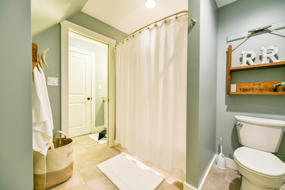 Design ideas for a mid-sized arts and crafts kids bathroom in Portland Maine with beaded inset cabinets, white cabinets, an alcove tub, a shower/bathtub combo, a two-piece toilet, blue walls, ceramic floors, an undermount sink, granite benchtops, beige floor and a shower curtain.