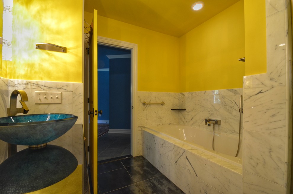 Photo of an eclectic kids bathroom in New York with a drop-in tub, a shower/bathtub combo, black and white tile, marble, yellow walls and a vessel sink.