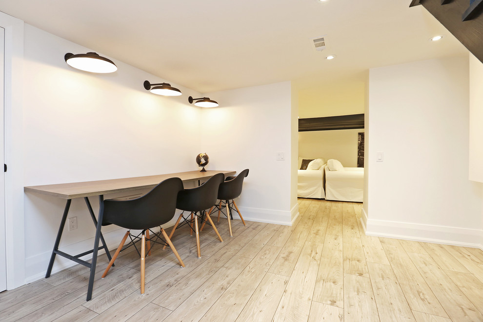 Photo of a large scandinavian look-out basement in Toronto with white walls and light hardwood floors.
