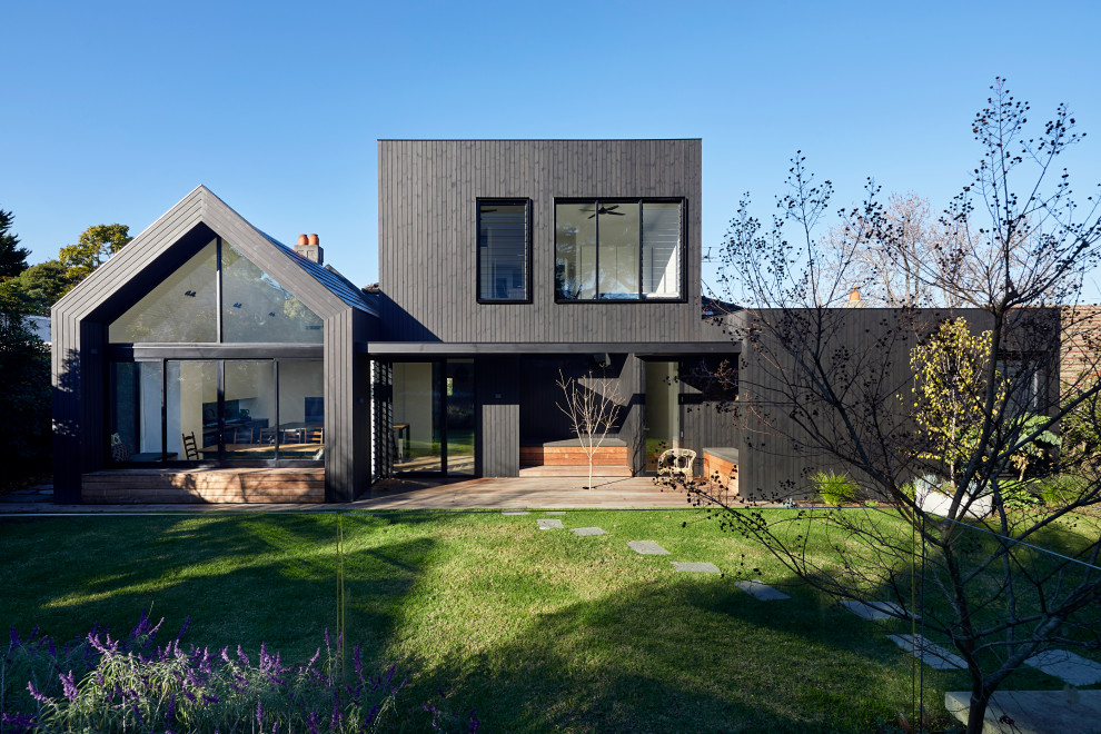 Design ideas for a large contemporary two-storey brown house exterior in Melbourne with mixed siding, a clipped gable roof, a mixed roof, a brown roof and board and batten siding.