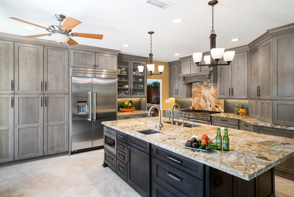 Design ideas for a mid-sized transitional l-shaped open plan kitchen in Orange County with an undermount sink, shaker cabinets, grey cabinets, granite benchtops, grey splashback, glass tile splashback, stainless steel appliances, porcelain floors and with island.