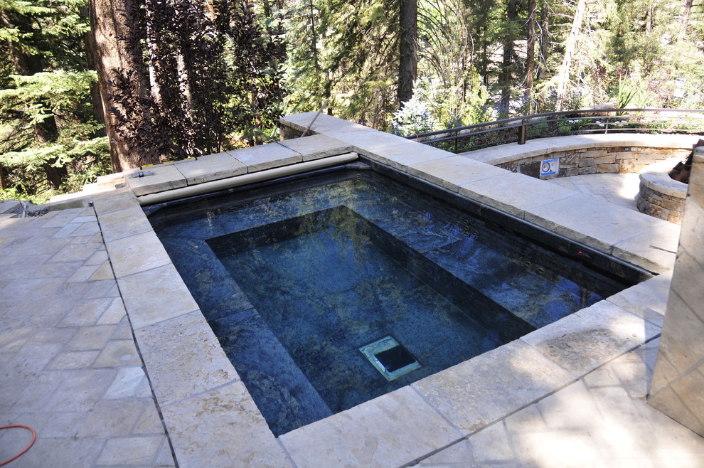 Minimalist backyard stone and custom-shaped hot tub photo in Denver