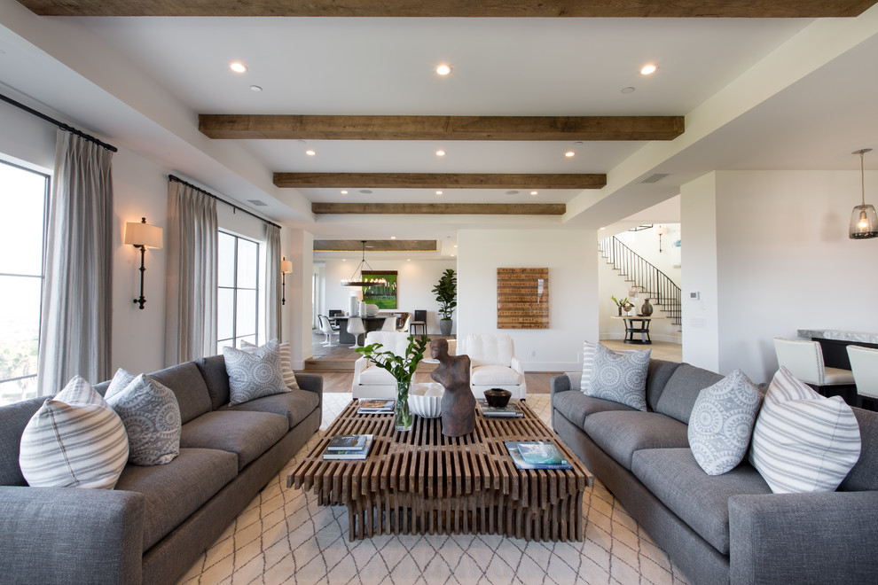 Example of a huge transitional open concept light wood floor living room design in Orange County with a bar, white walls, a standard fireplace, a concrete fireplace and no tv