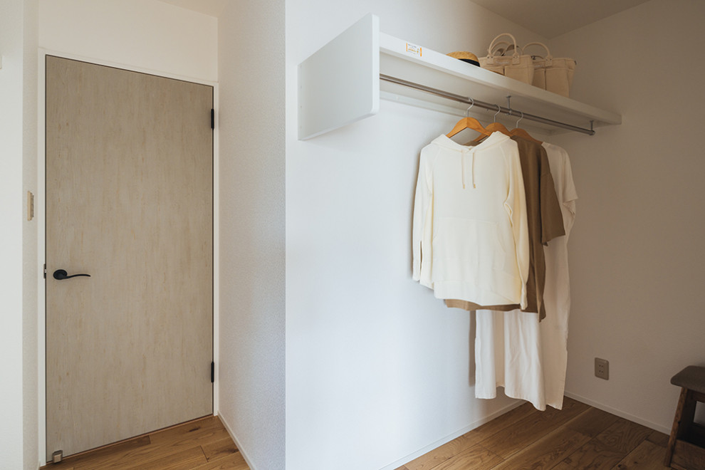 Exempel på en mellanstor garderob, med ljust trägolv och beiget golv