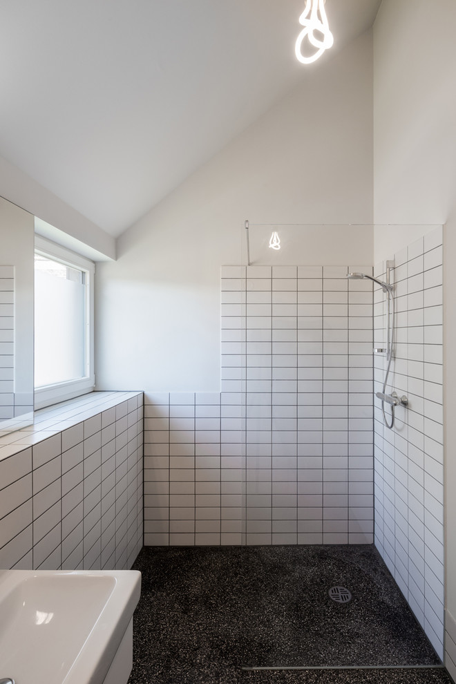 Kleines Modernes Duschbad mit bodengleicher Dusche, Wandtoilette mit Spülkasten, Steinfliesen, weißer Wandfarbe, Terrazzo-Boden, Wandwaschbecken, schwarzem Boden, offener Dusche und weißen Fliesen in Hamburg