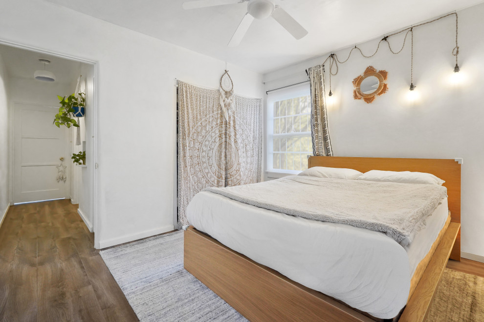 ロサンゼルスにある中くらいな地中海スタイルのおしゃれな客用寝室 (白い壁、無垢フローリング、マルチカラーの床) のレイアウト