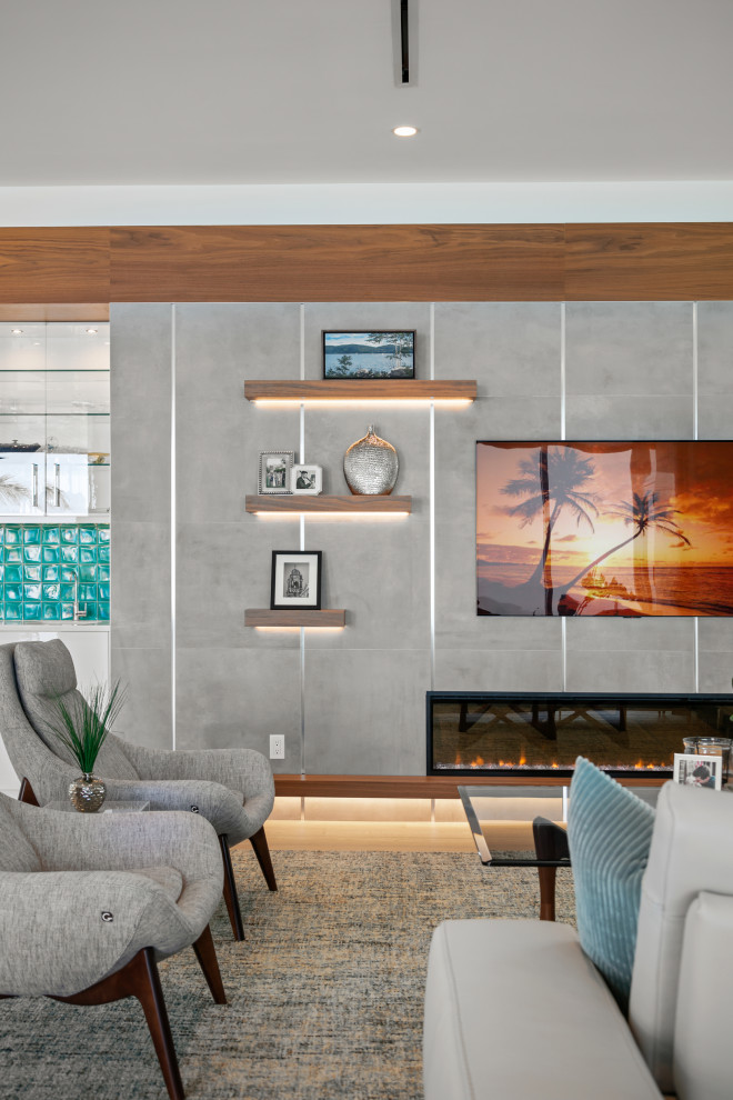 This is an example of a medium sized open plan living room in Tampa with a home bar, white walls, light hardwood flooring, a ribbon fireplace, a tiled fireplace surround, a wall mounted tv and brown floors.