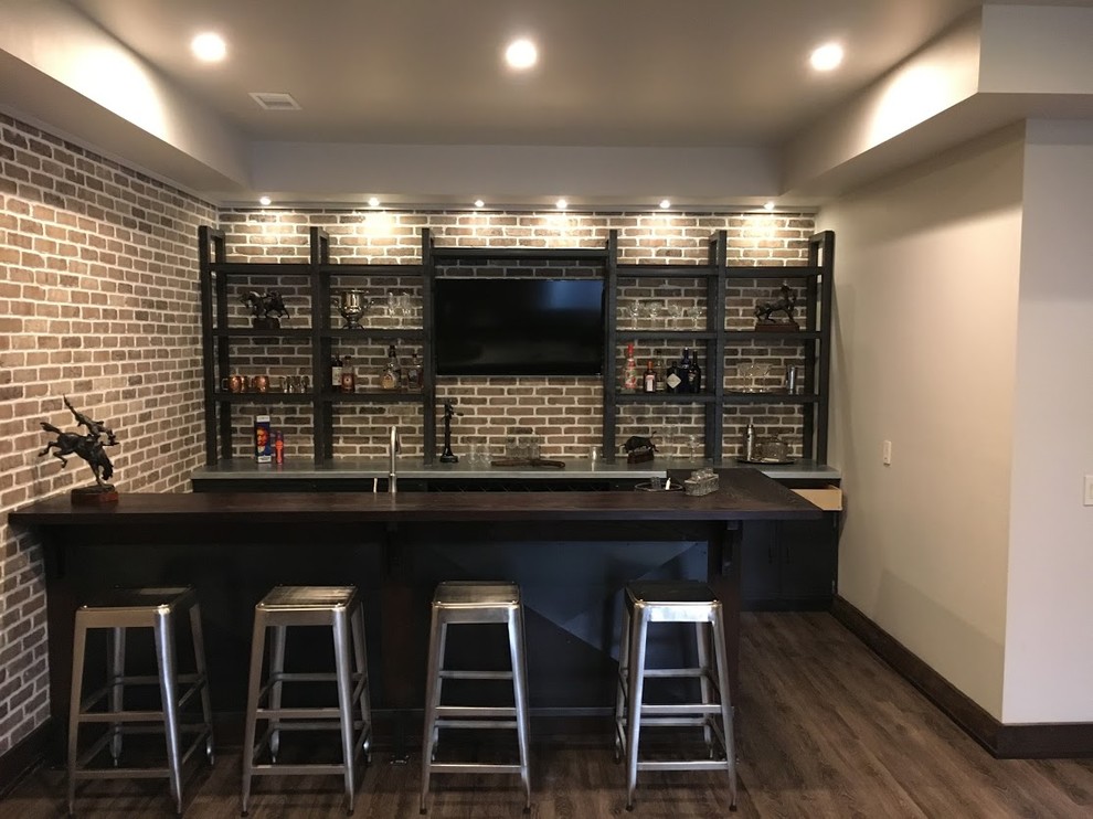 Design ideas for a mid-sized industrial galley seated home bar in Atlanta with a drop-in sink, black cabinets, concrete benchtops, brown splashback, brick splashback, dark hardwood floors, brown floor and recessed-panel cabinets.