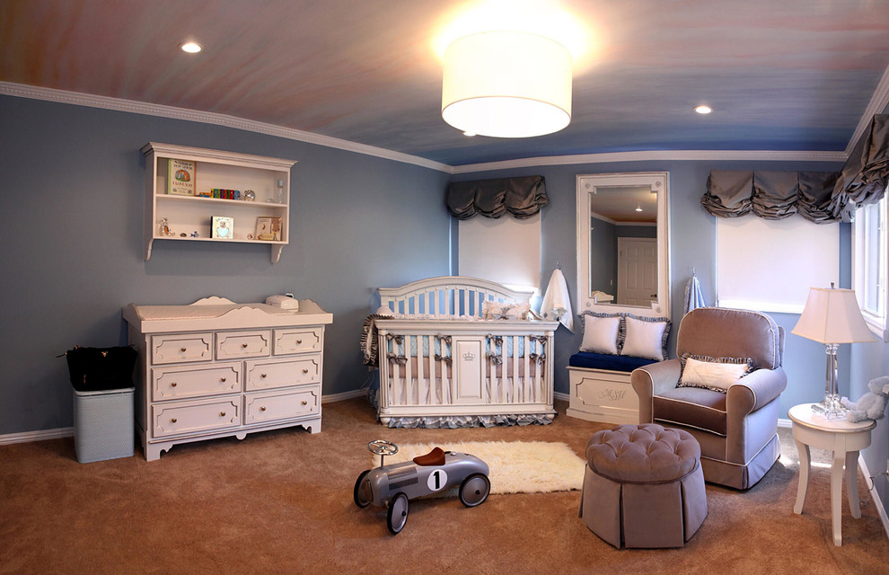 Photo of a mid-sized traditional nursery for boys in Los Angeles with blue walls and carpet.