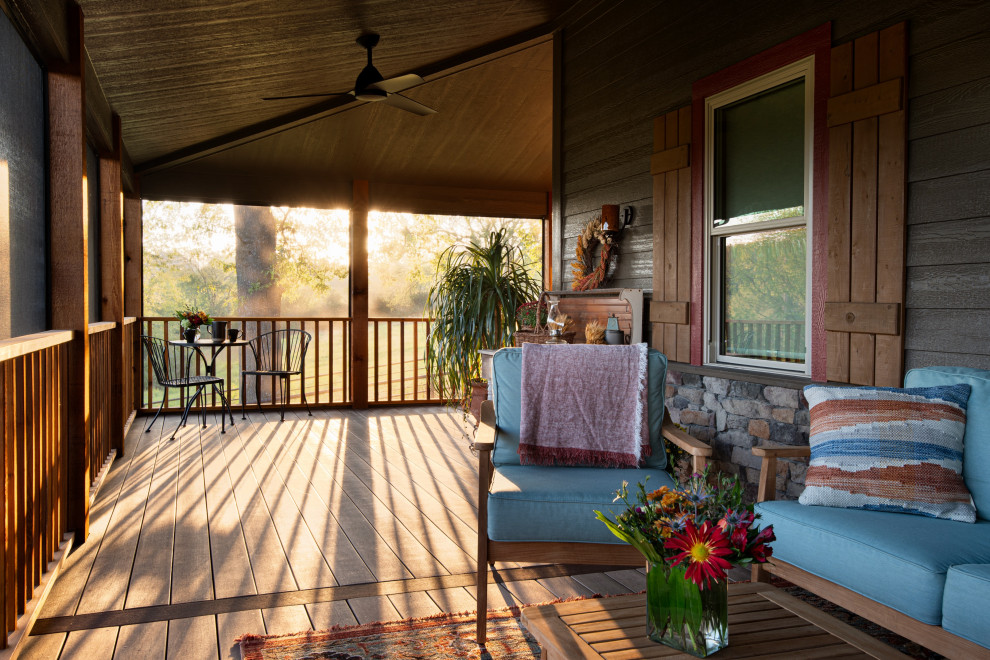 Idée de décoration pour un grand porche d'entrée de maison avant tradition avec une moustiquaire, une extension de toiture et un garde-corps en bois.